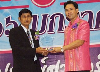 Kasem Chiewjew (left), principal of Pattaya School No. 9, receives an award for outstanding principal of the year from Mayor Itthiphol Kunplome.